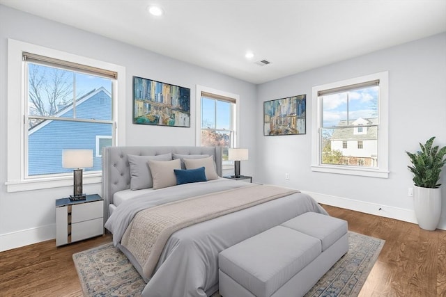 bedroom featuring dark wood-type flooring and multiple windows