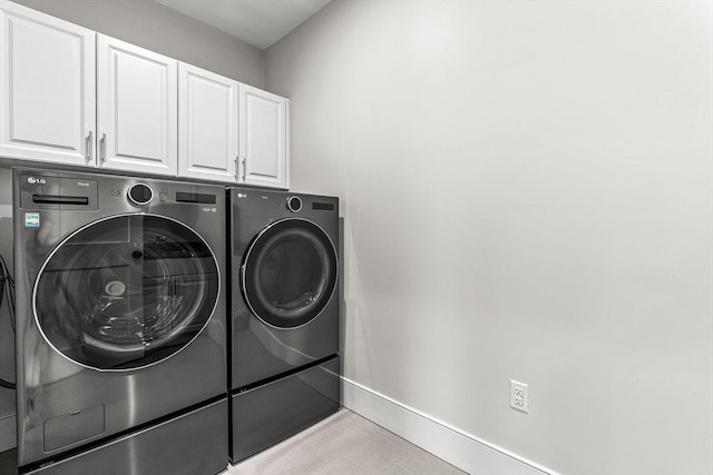 laundry room with cabinets and washer and clothes dryer