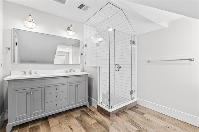 bathroom with a shower with door, vanity, and wood-type flooring