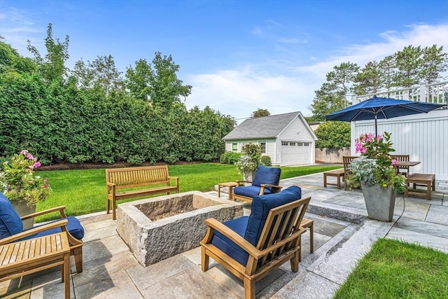 view of patio / terrace with a garage, an outdoor fire pit, and an outdoor structure