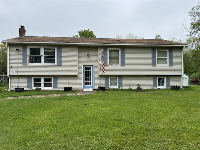 view of front of home with a chimney and a front yard