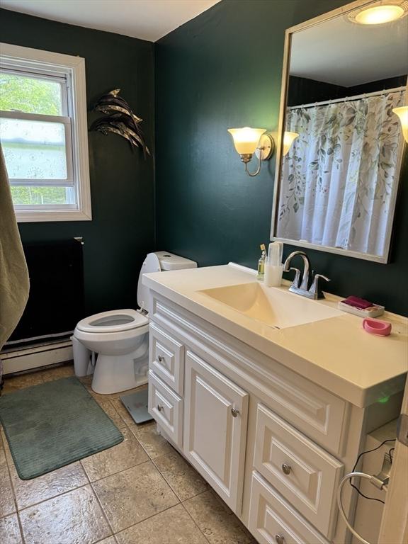 full bath featuring a baseboard radiator, toilet, and vanity