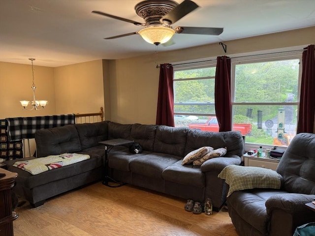 living area featuring light wood-style floors, ceiling fan, and a chandelier