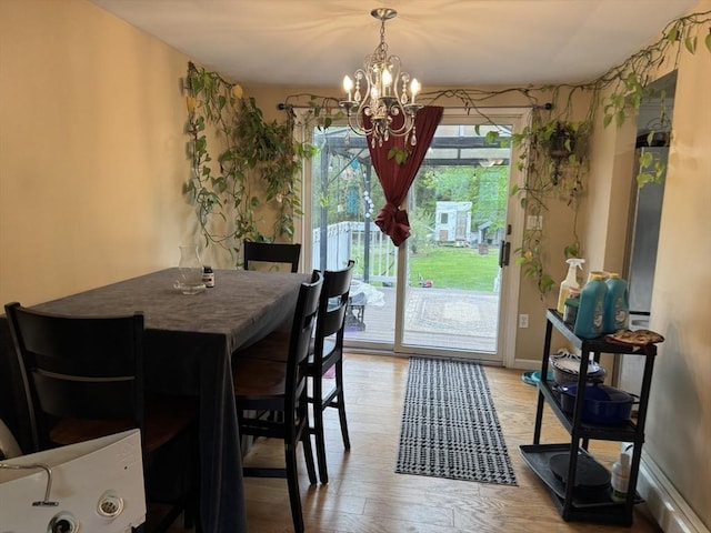 dining space with a chandelier and light wood-type flooring