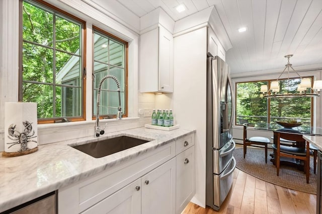 15 Youngs Rd, Gloucester, MA 01930 - kitchen with a sink, stainless steel refrigerator with ice dispenser, white cabinetry, light stone countertops, and light wood-style floors