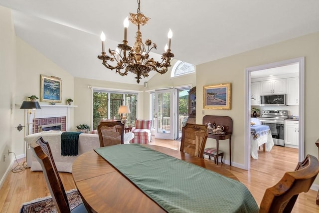 27 Quarryridge Ln Unit 27, Rockport, MA 01966 - dining area featuring a fireplace, a chandelier, lofted ceiling, and light wood finished floors