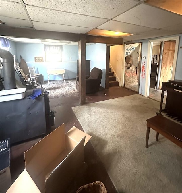 finished below grade area featuring stairs and a paneled ceiling