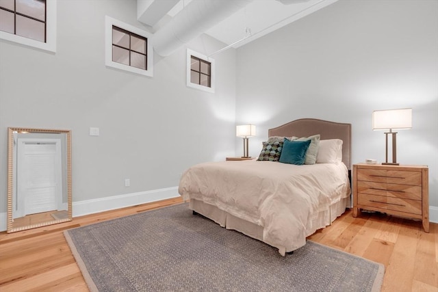 bedroom with light wood-type flooring and baseboards