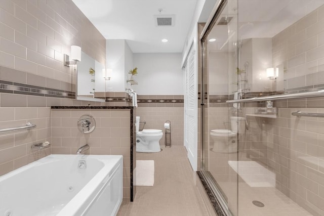 full bathroom with tile patterned flooring, a shower stall, tile walls, and toilet