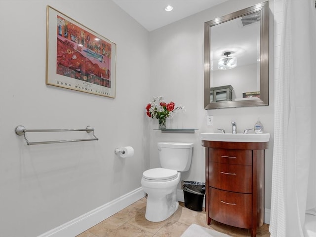 bathroom with vanity, toilet, and baseboards