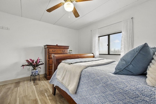 bedroom featuring light wood finished floors, baseboards, and a ceiling fan