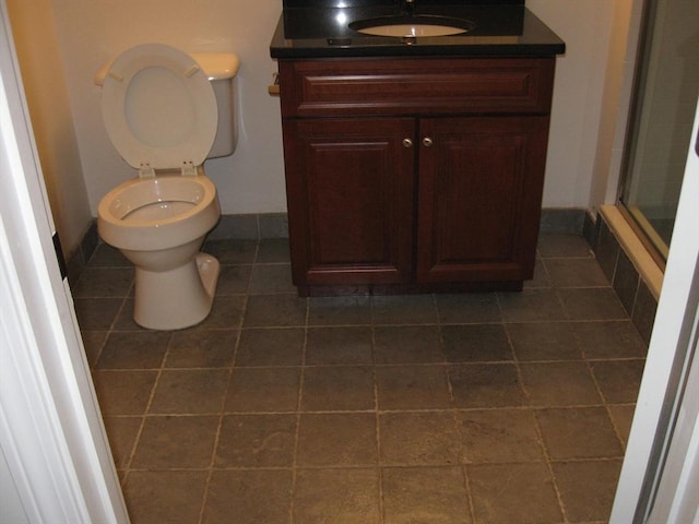full bath featuring an enclosed shower, baseboards, toilet, tile patterned floors, and vanity