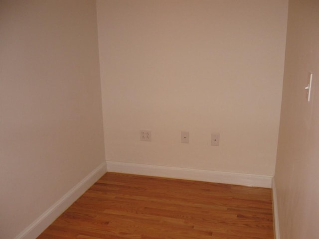 unfurnished room featuring baseboards and light wood-style floors