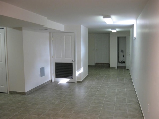 unfurnished living room with tile patterned floors, visible vents, and baseboards