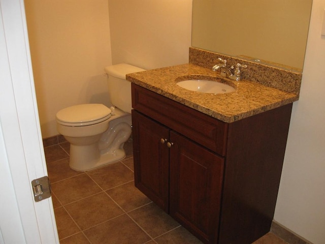 bathroom with toilet, tile patterned flooring, and vanity