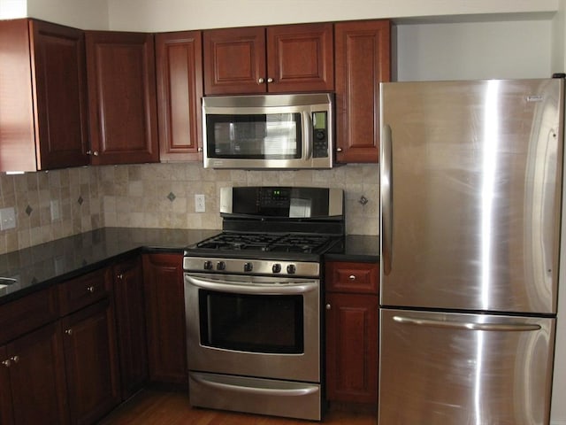 kitchen with backsplash, appliances with stainless steel finishes, and dark wood-type flooring