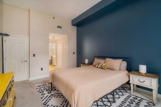 bedroom featuring a closet, carpet flooring, visible vents, and baseboards