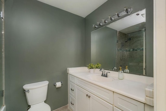 full bathroom featuring tiled shower, vanity, and toilet