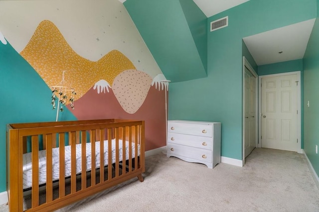 bedroom with a crib, carpet flooring, visible vents, and baseboards