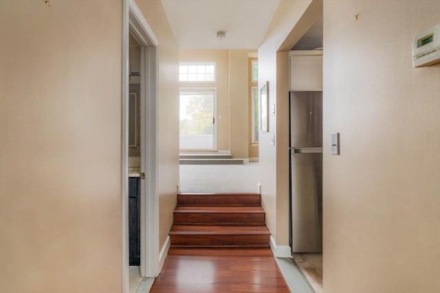 hallway featuring stairs, baseboards, and wood finished floors