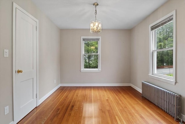 88 Cocasset St Unit 1, Foxboro, MA 02035 - spare room with radiator, light wood-style flooring, a chandelier, and baseboards