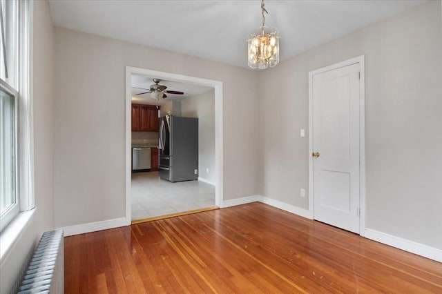 88 Cocasset St Unit 1, Foxboro, MA 02035 - empty room with radiator, light wood-style floors, ceiling fan, a chandelier, and baseboards