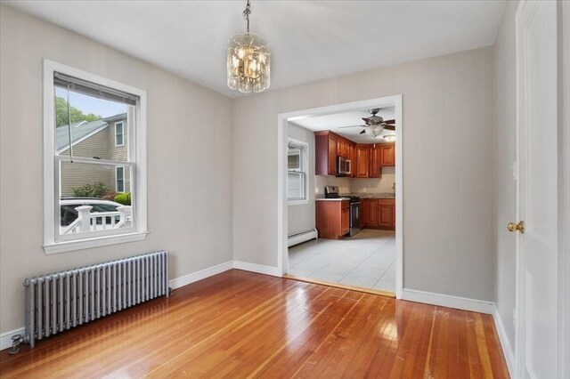88 Cocasset St Unit 1, Foxboro, MA 02035 - unfurnished dining area featuring radiator, a baseboard heating unit, baseboards, a chandelier, and light wood-style floors