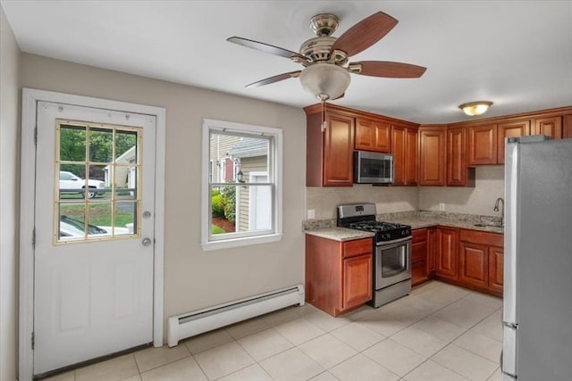 88 Cocasset St Unit 1, Foxboro, MA 02035 - kitchen featuring appliances with stainless steel finishes, a baseboard heating unit, a sink, light stone countertops, and a ceiling fan
