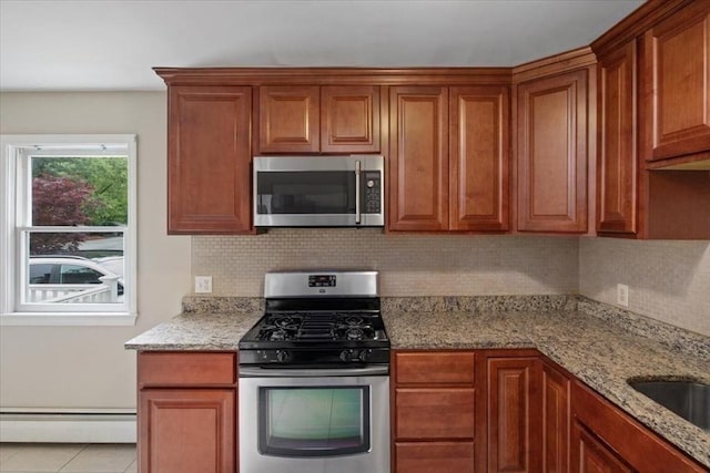 88 Cocasset St Unit 1, Foxboro, MA 02035 - kitchen with appliances with stainless steel finishes, a baseboard heating unit, decorative backsplash, and light stone countertops