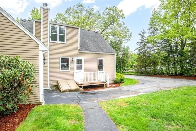 88 Cocasset St Unit 1, Foxboro, MA 02035 - back of property featuring a chimney, roof with shingles, and a lawn