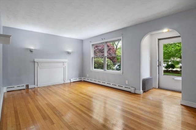 88 Cocasset St Unit 1, Foxboro, MA 02035 - unfurnished living room with a baseboard radiator, wood finished floors, and arched walkways