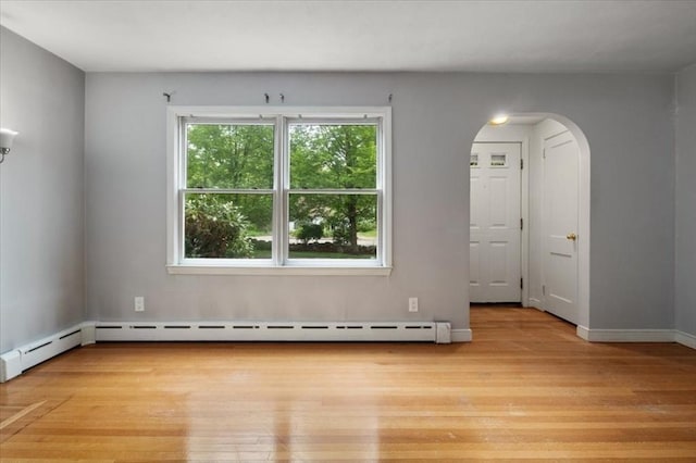 88 Cocasset St Unit 1, Foxboro, MA 02035 - unfurnished room featuring light wood-type flooring, arched walkways, baseboards, and a baseboard heating unit