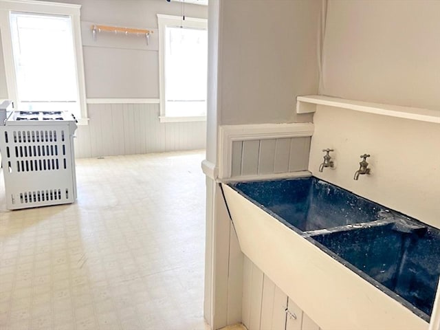 interior space with a wainscoted wall, light flooring, and stove