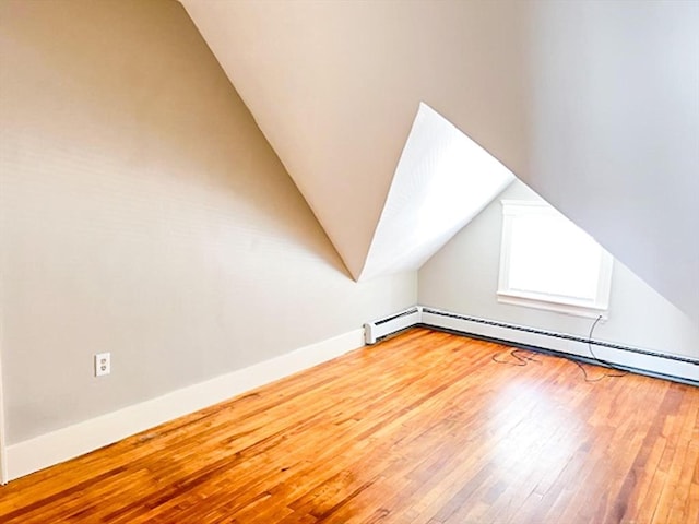 bonus room featuring hardwood / wood-style floors, vaulted ceiling, baseboards, and baseboard heating