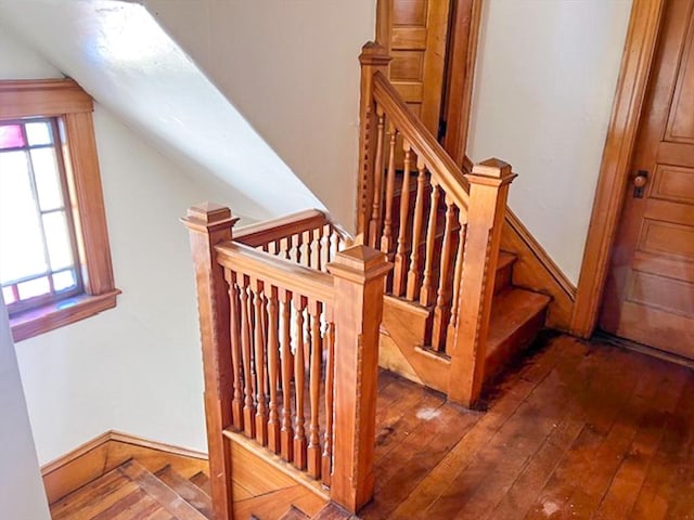 stairs featuring hardwood / wood-style flooring and lofted ceiling