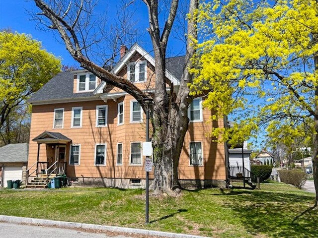 view of front of property with a front lawn and a shingled roof