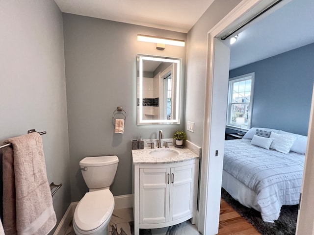 bathroom with hardwood / wood-style floors, vanity, and toilet