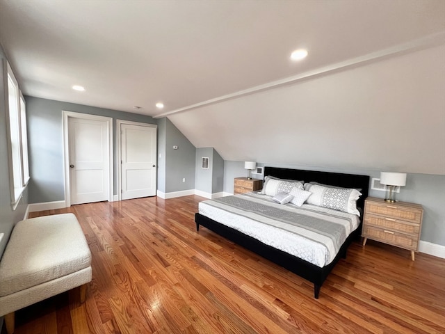 bedroom with wood-type flooring and lofted ceiling