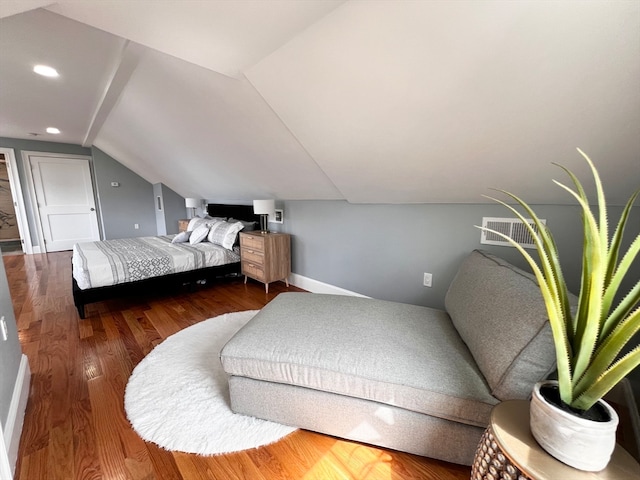 bedroom with wood-type flooring and vaulted ceiling