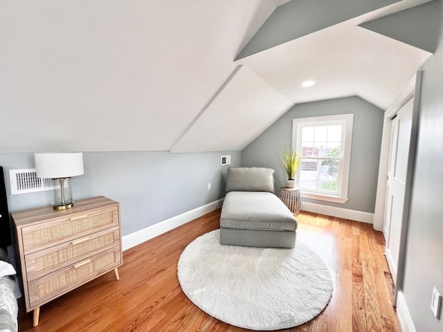 living area with hardwood / wood-style floors and lofted ceiling