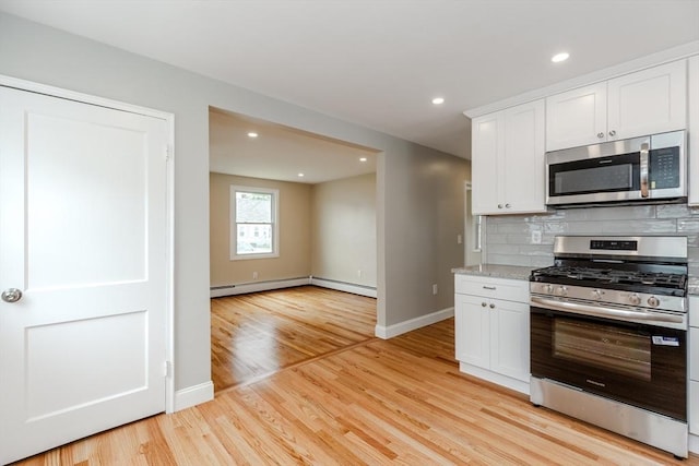 kitchen with appliances with stainless steel finishes, tasteful backsplash, white cabinets, baseboards, and recessed lighting