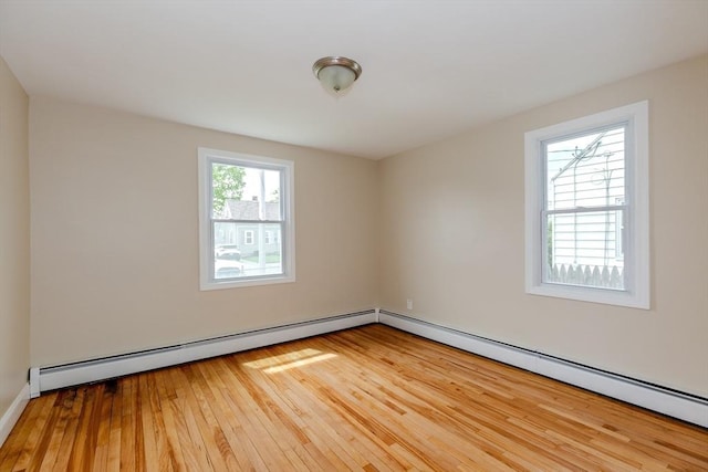 unfurnished room featuring wood-type flooring and a baseboard radiator