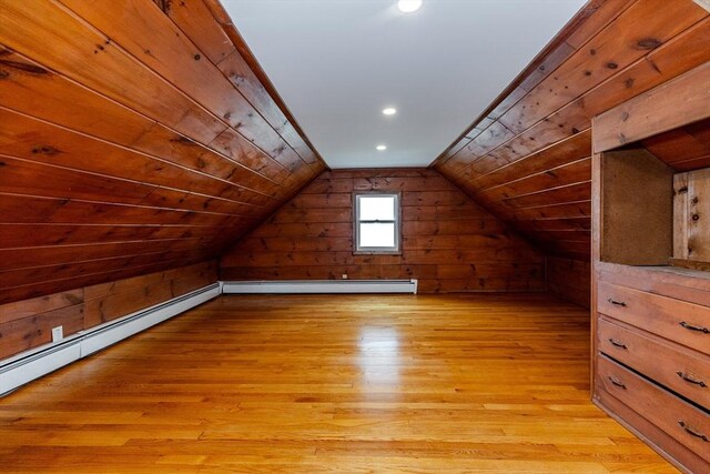additional living space with baseboard heating, wood walls, light wood finished floors, lofted ceiling, and recessed lighting