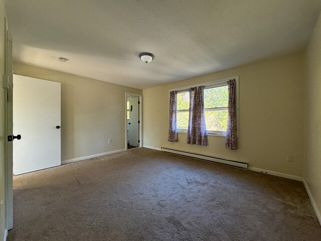 unfurnished room featuring baseboard heating and carpet flooring