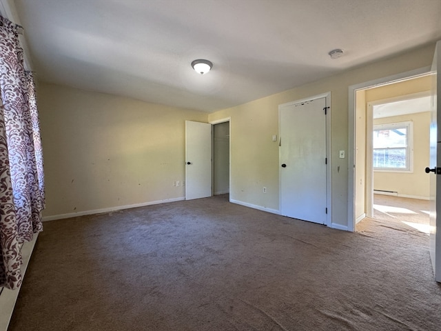 spare room featuring carpet floors and a baseboard heating unit