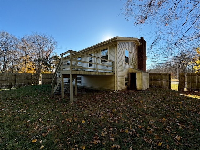 rear view of house featuring a wooden deck, a yard, and a storage shed