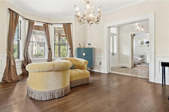 929 Beacon St, Newton, MA 02459 - living area featuring a chandelier, dark wood-style floors, a decorative wall, ornamental molding, and healthy amount of natural light