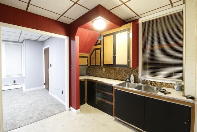 kitchen featuring a baseboard radiator, sink, a drop ceiling, light colored carpet, and decorative backsplash