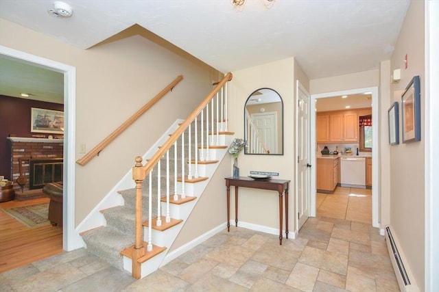 26 Kittredge St, Walpole, MA 02081 - stairs featuring baseboard heating, stone tile flooring, a brick fireplace, and baseboards