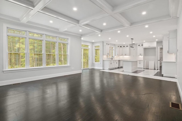 unfurnished living room with sink, beamed ceiling, and coffered ceiling